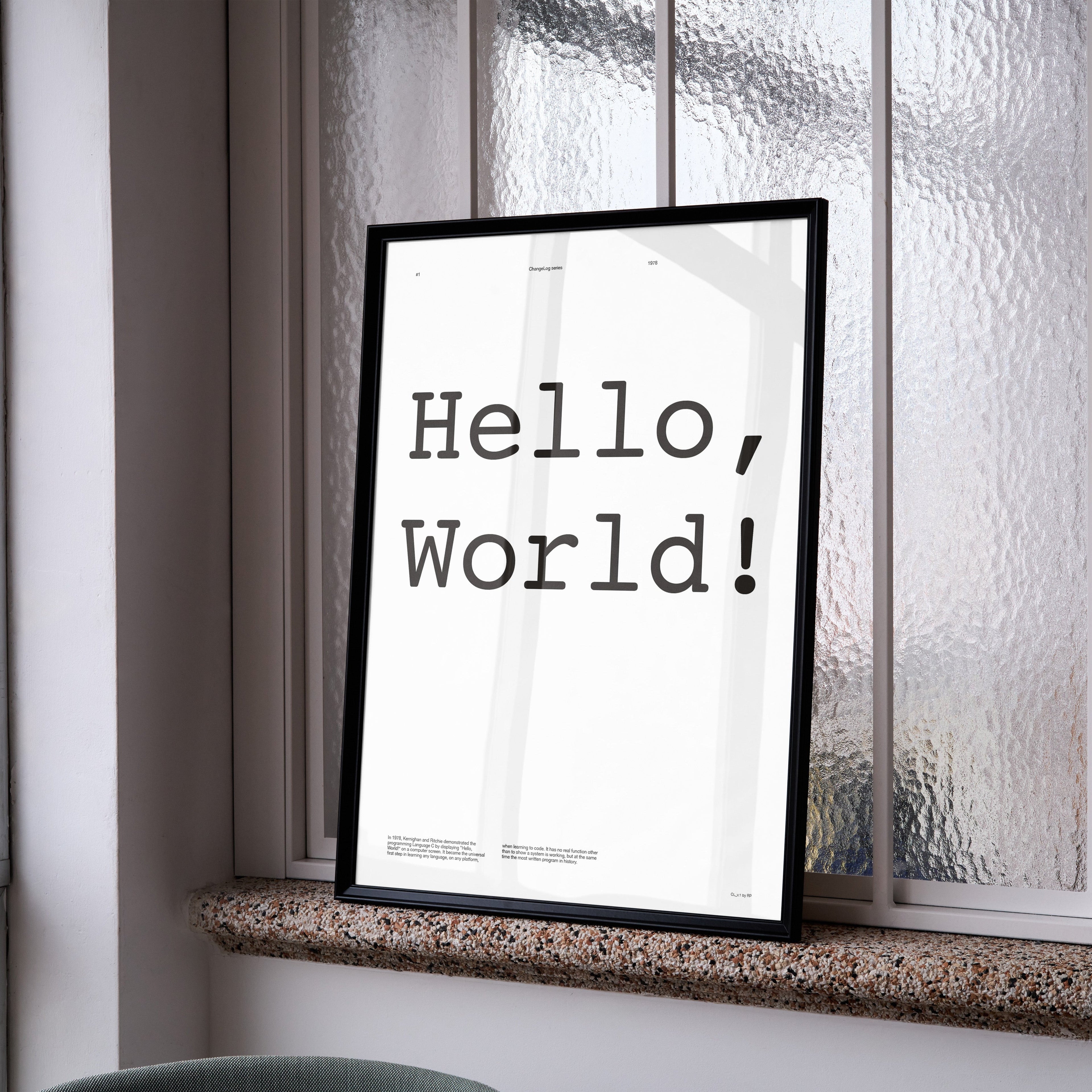 Framed 'Hello, World!' print on a window sill with a blurred background